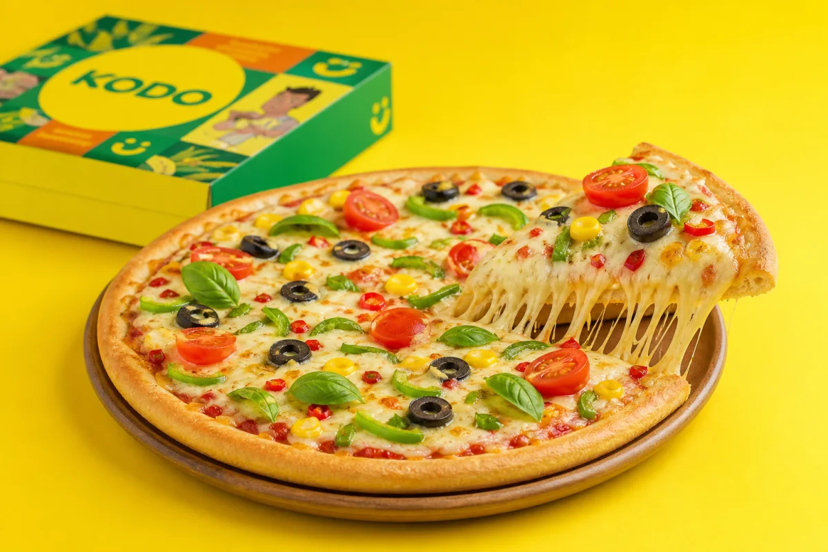 A Kodo millet-crust vegetable pizza with a lifted cheesy slice