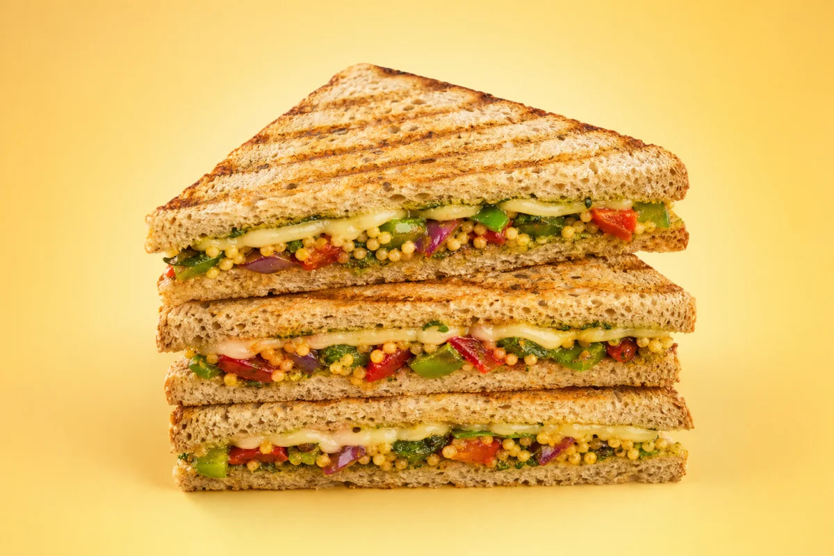 A stack of toasted multi-millet vegetable and cheese sandwiches